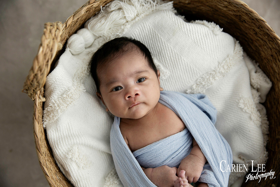 Newborn baby wrapped in soft blankets during Bunbury newborn photography session