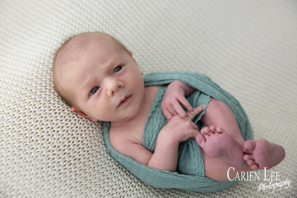 Newborn baby wrapped in soft blankets during Bunbury newborn photography session