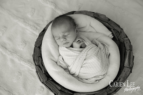 Newborn baby wrapped in soft blankets during Bunbury newborn photography session