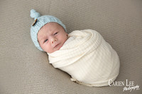 Newborn baby wrapped in soft blankets during Bunbury newborn photography session