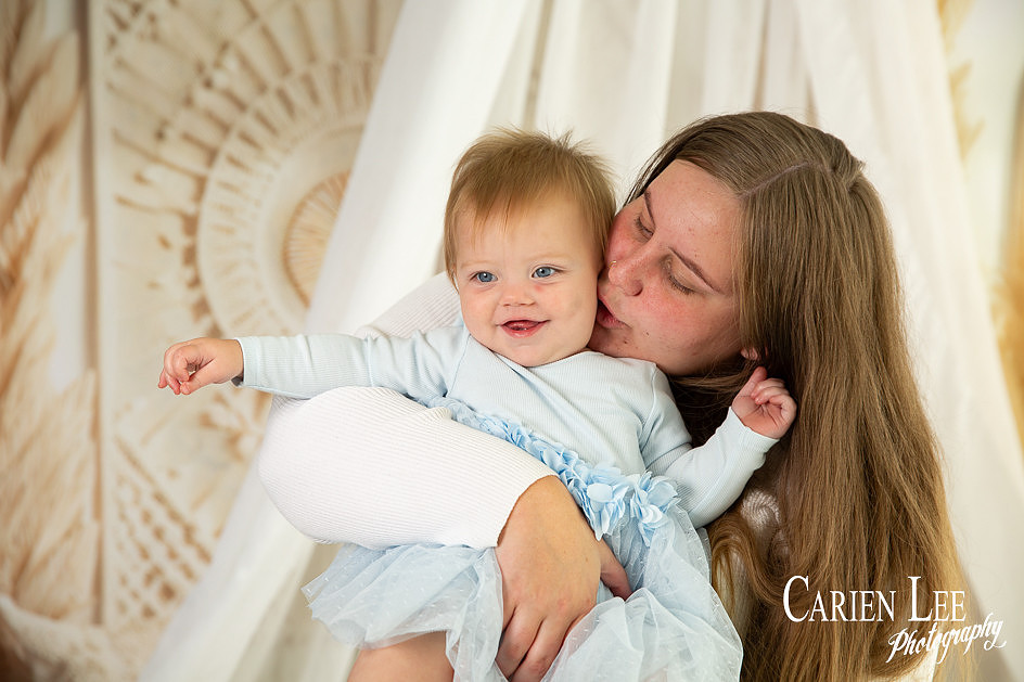 Mother cuddling her one-year-old daughter during a Mother’s Day studio session in Bunbury