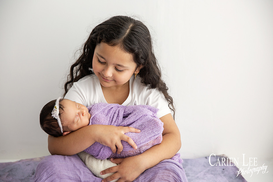 Photo of sibling love during a newborn family photo session in Bunbury