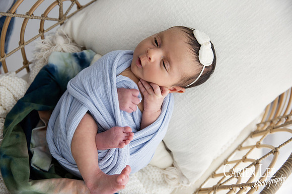 Newborn girl wrapped and cuddly in Bunbury Studio