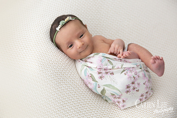 Newborn girl wrapped in flowery wrap in Bunbury Studio