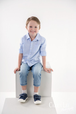 Photo of a young boy in timeless white studio