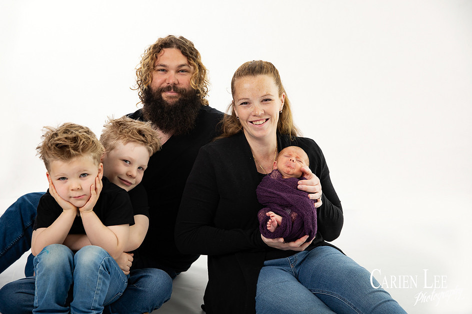 Family and newborn photography session in Bunbury showing parents cuddling their newborn baby.