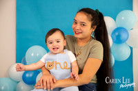 One year old baby boy Elijah sitting in a blue and white birthday photography setup