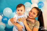 Baby boy celebrating turning one with a blue and white themed milestone photo session