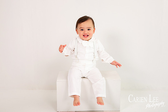 Baby boy celebrating turning one with a blue and white themed milestone photo session
