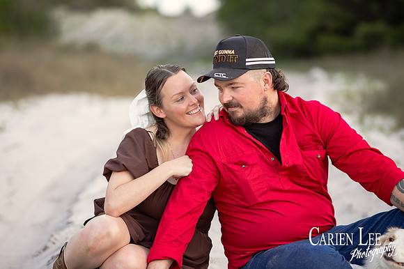 ouple sitting together with dog resting at their feet during Bunbury shoot