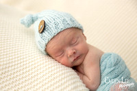 Newborn baby Noah in classic curled sleeping pose, Bunbury photography studio