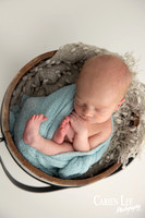 Peaceful newborn baby wrapped snugly, deep sleep during Bunbury photoshoot