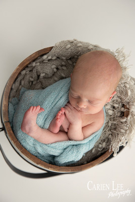 Peaceful newborn baby wrapped snugly, deep sleep during Bunbury photoshoot