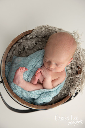 Peaceful newborn baby wrapped snugly, deep sleep during Bunbury photoshoot