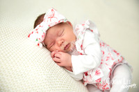 Newborn girl wearing a big bow headband during a newborn shoot