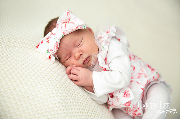 Newborn girl wearing a big bow headband during a newborn shoot