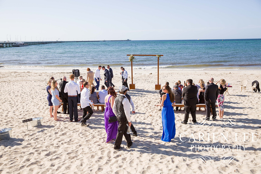Guests and groom at the wedding ceremony on Busselton Beach at Busselton Jetty