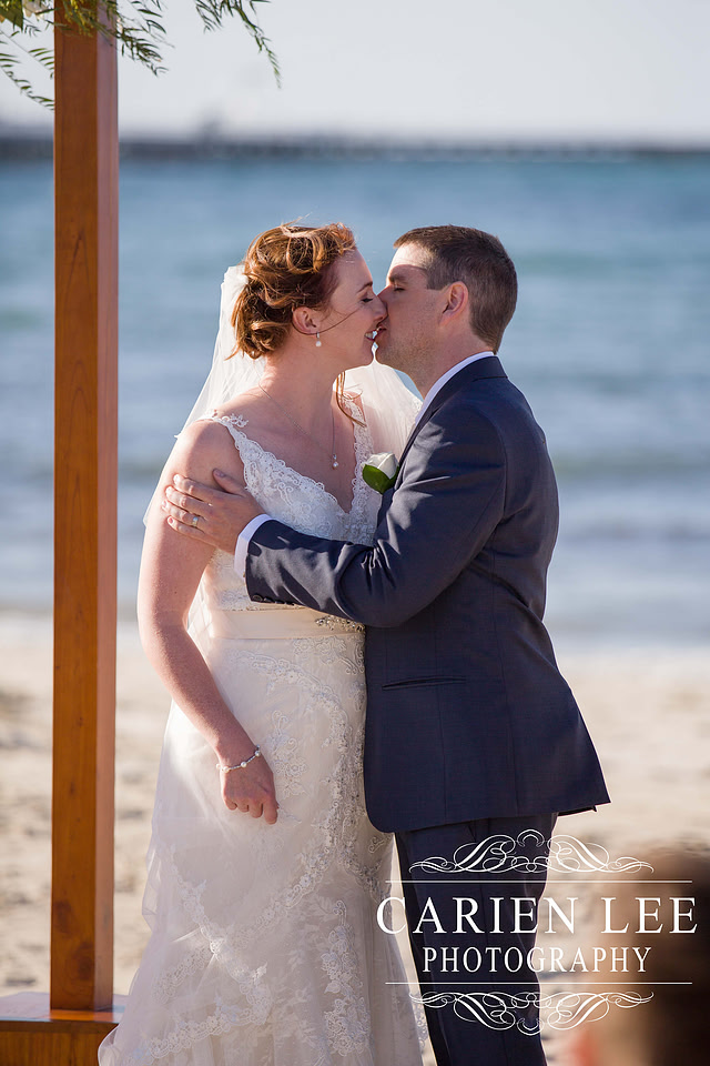 Bride and groom fist kiss at busselton beach wedding ceremony